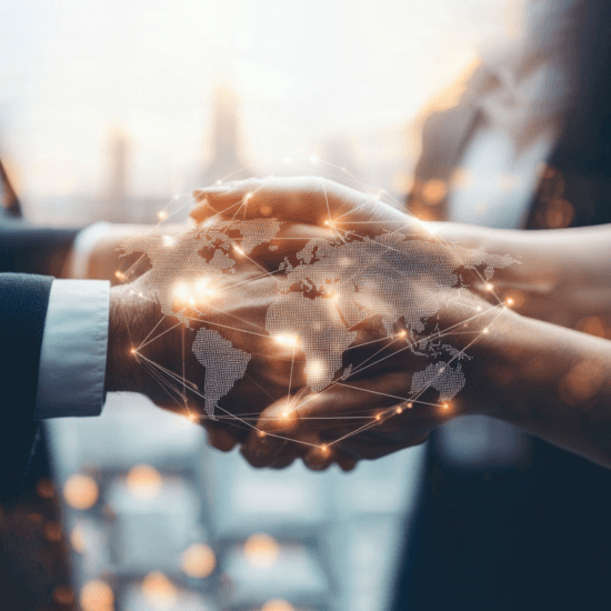 Two business individuals shaking hands over a world map, representing international cooperation and networking.