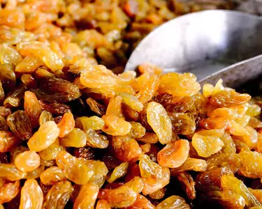 A collection of raisins stacked together, highlighting their rich color and unique shapes.